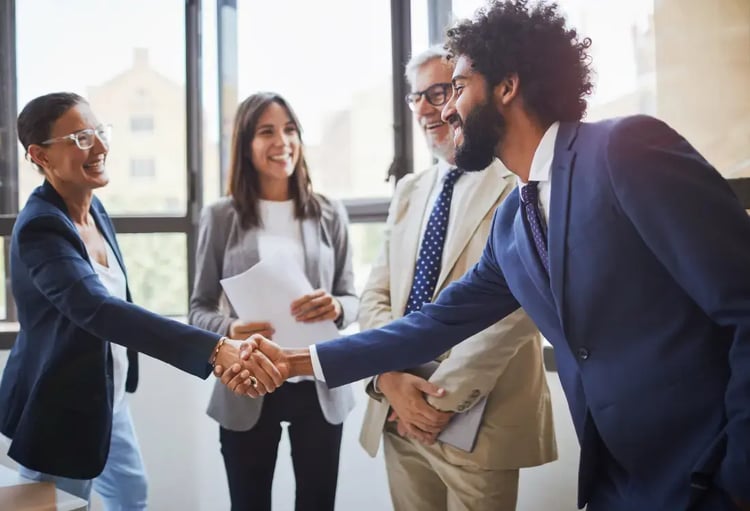 A contract manager and a supplier shaking hands after their meeting. 