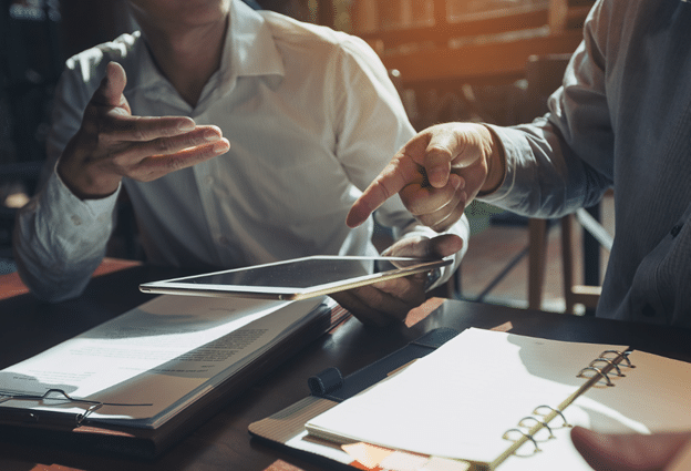 Two people discussing the best ways to improve procurement processes without damaging their relationship with their suppliers. 